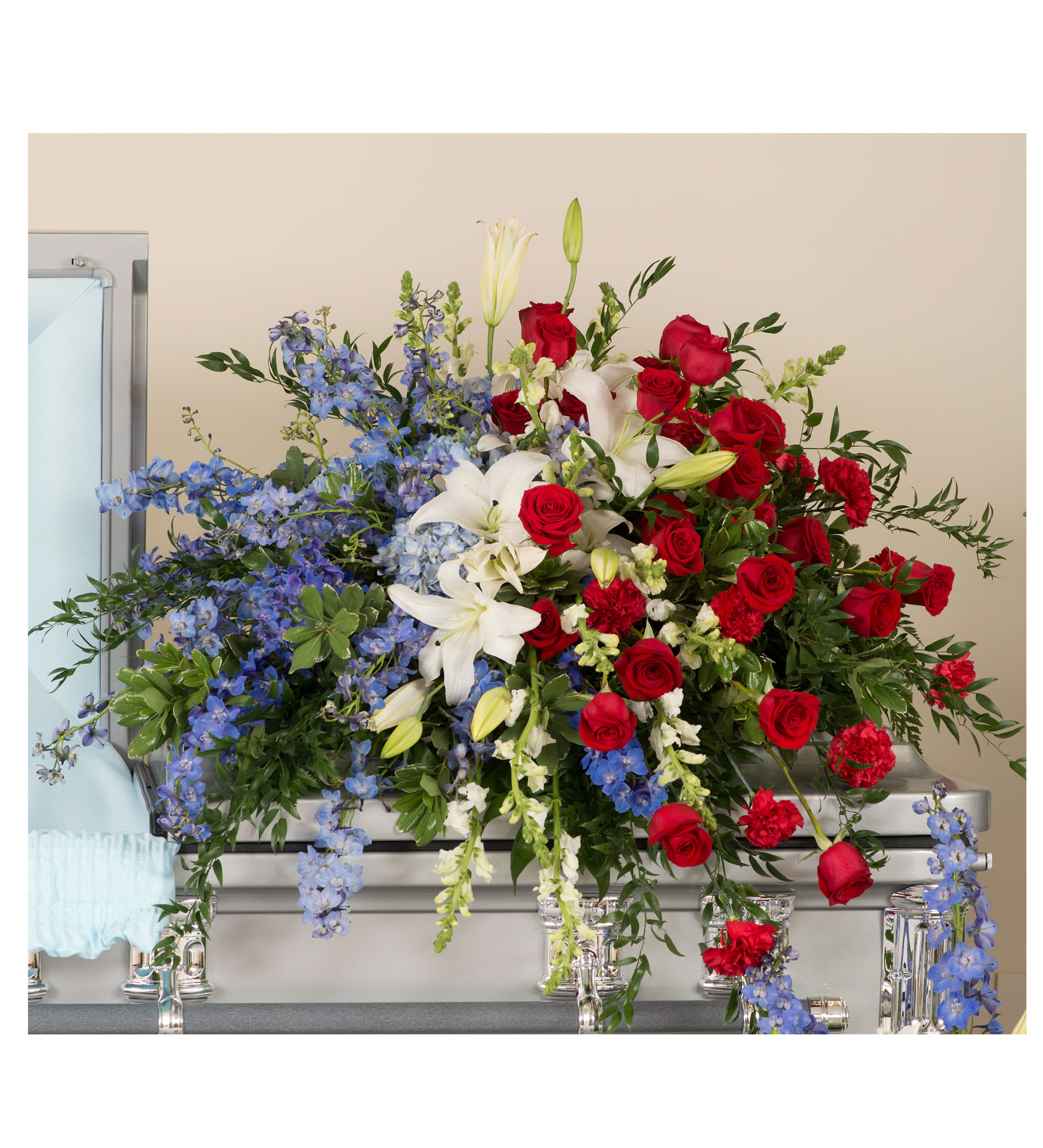 PATRIOTIC CASKET SPRAY - Elegant patriotic colored casket spray of roses, lilies, and delphinium.
