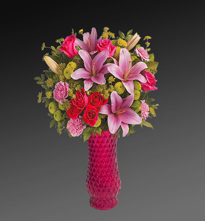 Dressed To Impress Flowers - What's better than pink? More pink! This blissful bouquet of roses and lilies is arranged and delivered by a local florist in a classic glass vase. This flower arrangement is sure to put some pink in their cheeks and a smile on their faces! This beautiful bouquet features hot pink roses, hot pink spray roses, pink asiatic lilies, pink carnations, green button spray chrysanthemums, bupleurum, huckleberry and lemon leaf. Orientation: One-Sided  SUBSTITUTION POLICY - Always deliver the freshest flowers! Please note the bouquet pictured reflects our original design.  If the exact flowers or container in this arrangement are not available, our local florists will create a beautiful bouquet with the freshest available flowers.