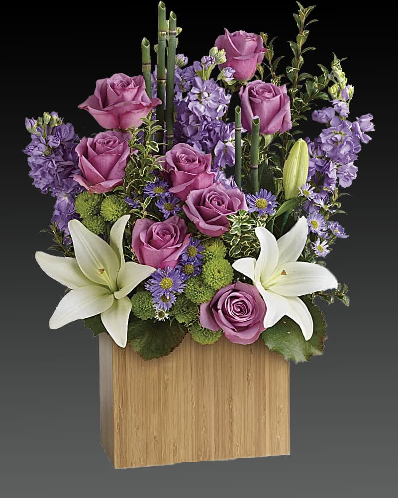 Kissed With Bliss Flowers - Send serenity. An artistic expression of love and peace, this luxurious lavender and white bouquet is presented in our stylish bamboo rectangular vase. Accented with exotic greens, it brings natural serenity to any space. Includes lavender roses, white asiatic lilies, lavender stock, monte cassino asters and green chrysanthemums, accented with fresh greenery. Delivered in Teleflora's large Bamboo Rectangular vase. Orientation: All-Around