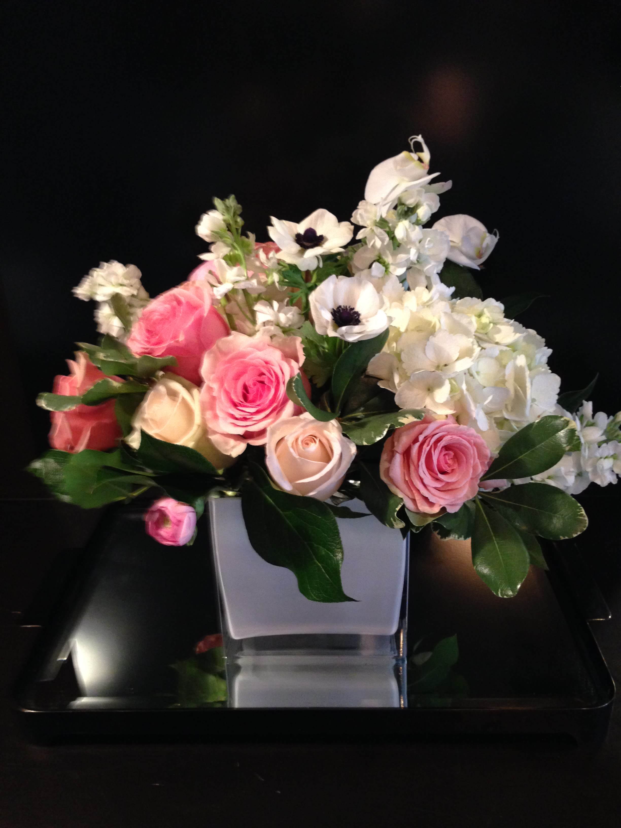 Think Pink  - White Roses, Pink Roses, White Hydrangea and White Anemones arranged in a white cube vase 