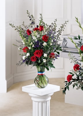 Salute to a Patriot Bouquet Salute to a Patriot Bouquet - A appropriate display of respect and sympathy. This arrangement takes red roses and carnations and surrounds them with blue larkspur and white mini carnations and snapdragons. Appropriate to send to a home or to a funeral. Approximately 27H" X 17W"