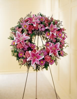 We Fondly Remember Wreath We Fondly Remember Wreath - "Stargazer lilies are used to remind how special she was in this soft pink wreath. Appropriate to send to the funeral home. Arrangement is delivered with an easel for display. Approximately 24"" dia.H"" X W"""