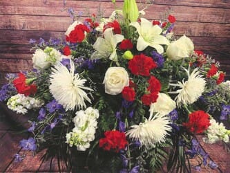 For Love of Country Casket Spray - 15&quot;H x 32&quot;W x 40&quot;L Deluxe (CS14-1D) $365 (pictured) Premium (CS14-1P) $475 Red, white and blue casket spray featuring roses, spider mums, Asiatic lilies, carnations, miniature carnations, stock and delphinium.