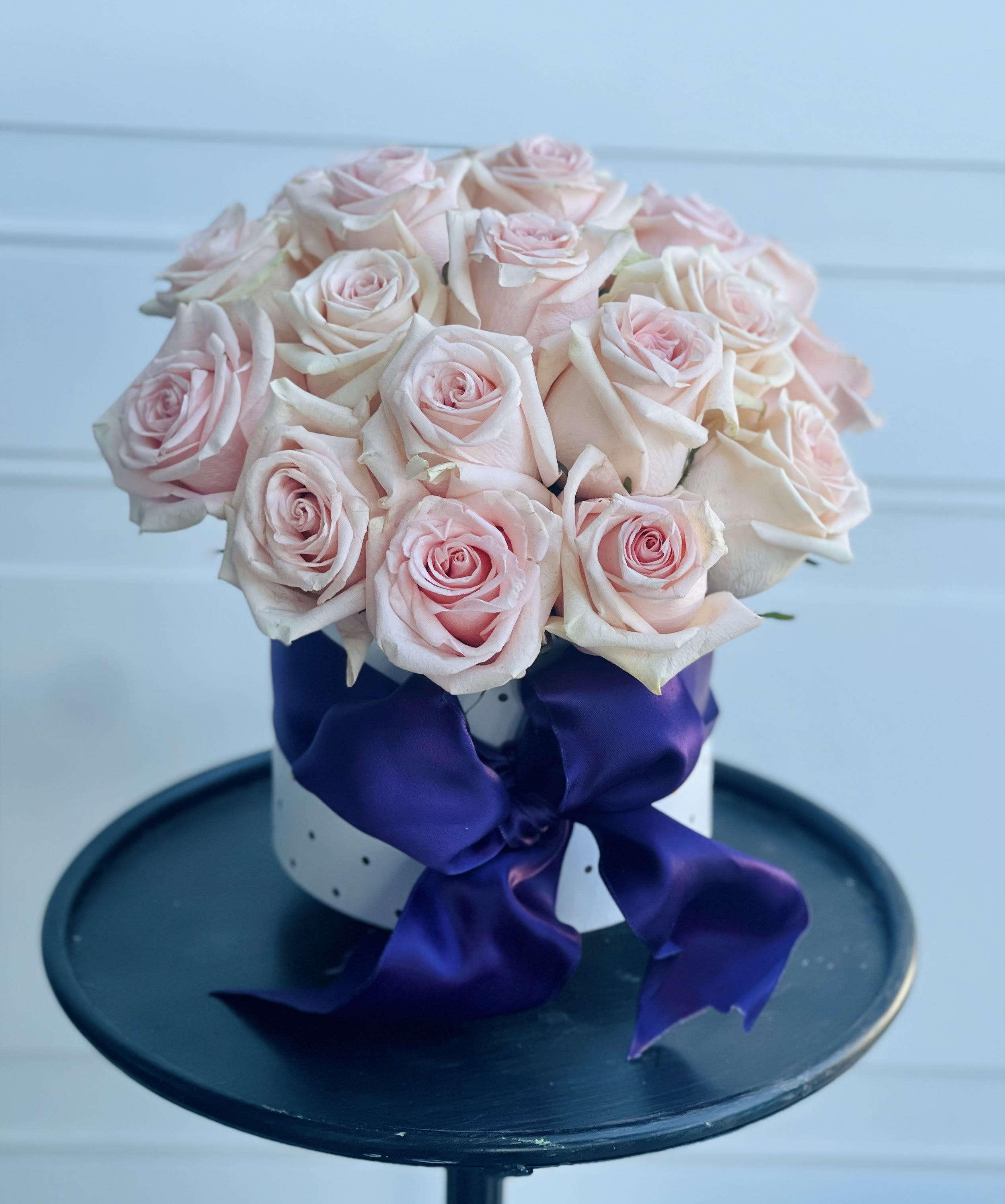 luxe - The arrangement is presented in a white hatbox with darling shimmer polka dots, tied with a giant fluffy oversized purple satin bow, and filled with our most premium handpicked blush garden roses.