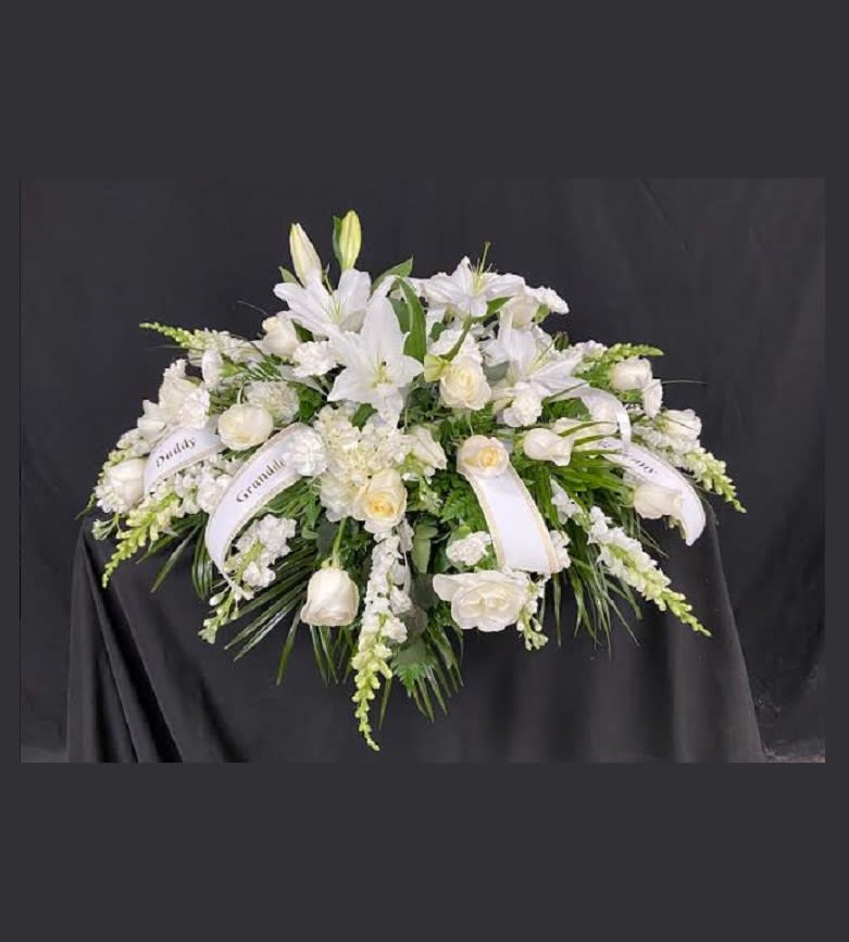 Mixed White Florals Casket Spray - A mix of all white flowers including roses, lilies, carnations, mini carnations, mums, larkspur, snap dragons, and stock. Price includes up to 4 custom printed ribbons.