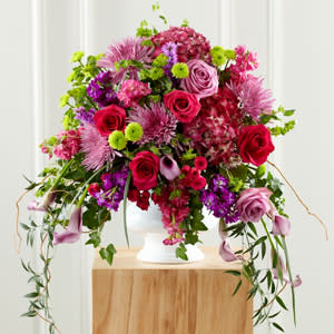 Our Love Eternal Arrangement - This vibrant arrangement of purple and pink roses, calla lilies, mums, stock, and hydrangea blooms is a special memorial of the colorful life of your loved one.
