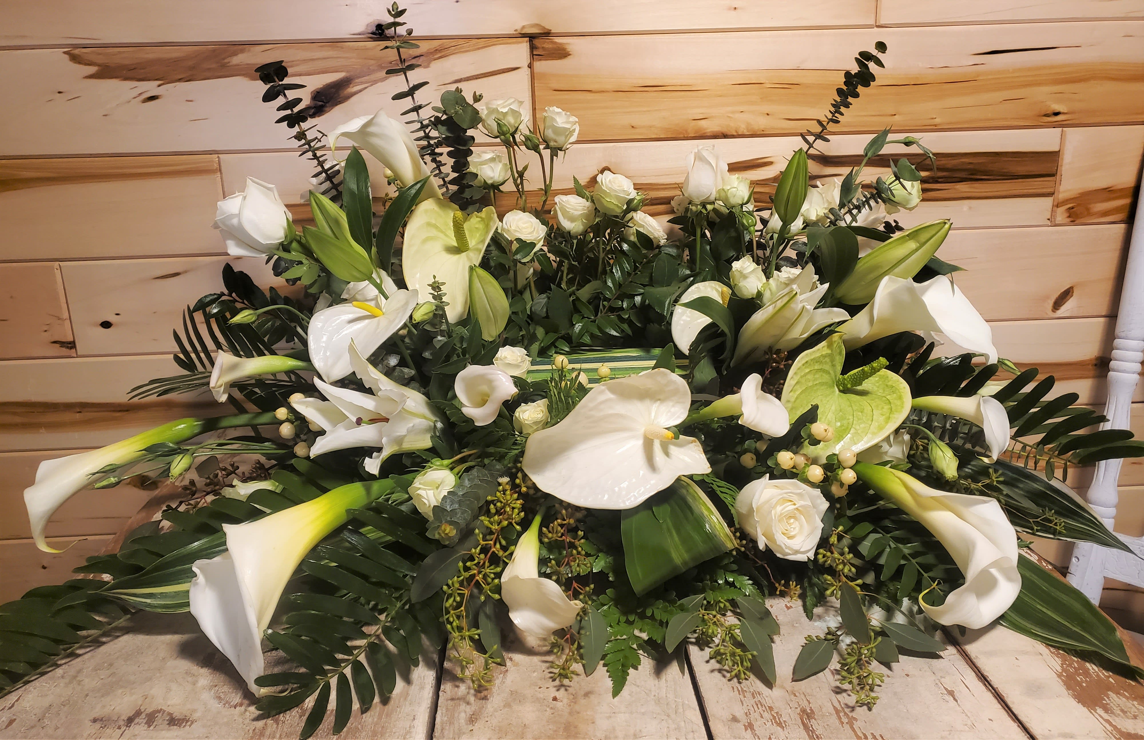 Fancy White Urn Surround - Surround the urn of your loved one with some very elegant white flowers. Large and mini white callas, white anthurium, white roses, white spray roses, white berries, white lisianthus and white casablanca lilies.  