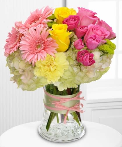 Fashionista - A fashionista is someone who’s always on the cutting edge of fashion and life. Send a glamorous floral gift to the style maven in your life.  This design includes roses, gerberas, and hydrangea in delicate hues of pinks, yellows, and greens – all dressed up with ribbon and raffia.