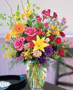 The Dazzler - With this exceptional arrangement of bright pink, red, yellow, and purple florals, you can show that special someone just how much they really count.  Alstroemeria, roses, gerberas, snapdragons, and other flowers in the season are designed among a variety of greenery in a clear glass vase.