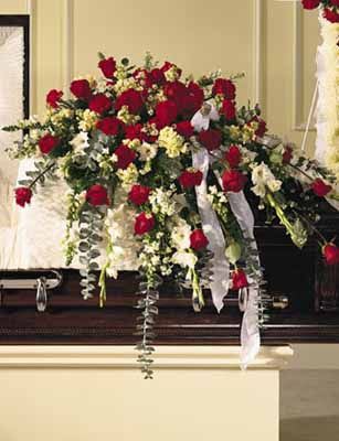 Sympathy Casket Spray - This bountiful casket saddle measures 15''x10.5'' and makes a stately and regal remembrance piece. Red and white blooms of Roses, Snapdragons, white Gladioli, red Carnations, cream Stock, white Monte Casino, baby blue Eucalyptus, and Leatherleaf give it its noble appearance. Suitable for funeral service.