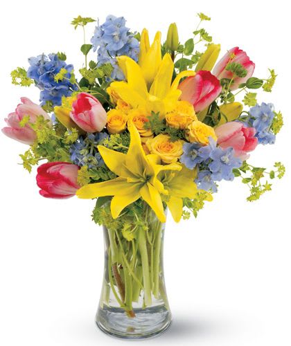 Spring Delight - Send all the joy of Springtime, captured in a bright mix of yellow Asiatic lilies and roses, pink tulips and delphinium as blue as a spring sky.  It's a precious bouquet that will be received with great joy.
