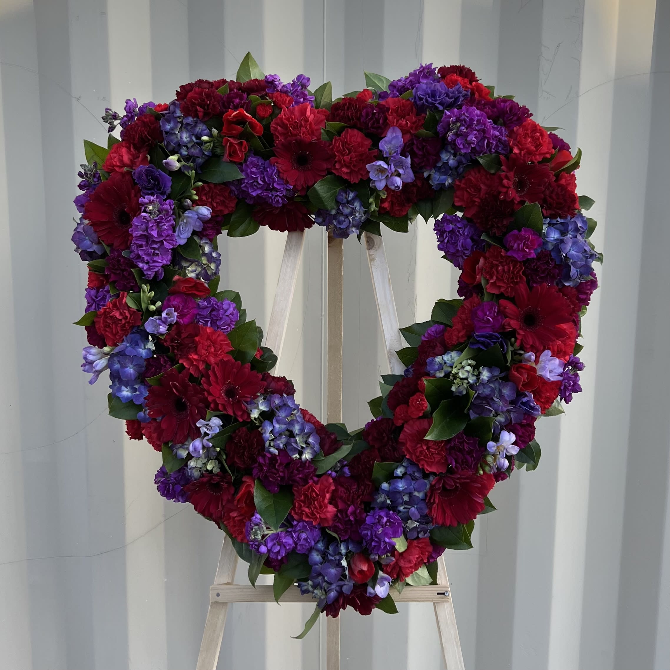 PURPLE HEART WHREATH - This heart wreath has fresh local and imported flowers. 