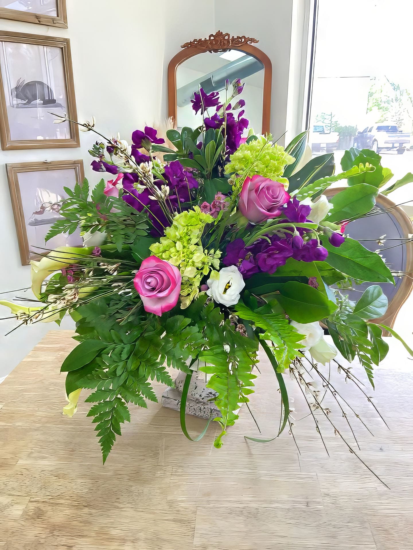 Purple and Pink - Purple stock, green hydrangeas with fern and other greens make up this arrangement.  Perfect for any occasion.  In a ceramic pot. 