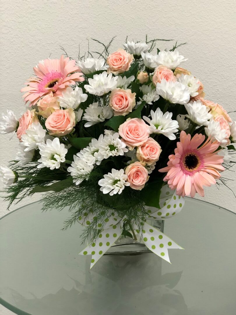 POLKA DOTS POLKA DOTS - "Polka dots and posies, they’re the perfect pair. Well, at least in this pretty arrangement they are. Just the right flowers in just the right vase all wrapped up in… you guessed it, just the right ribbon. Pink spray roses and white daisy spray chrysanthemums are delivered in an exclusive pink vase that’s wrapped with a polka-dot satin ribbon. SET: All-Around All prices in USD ($)"