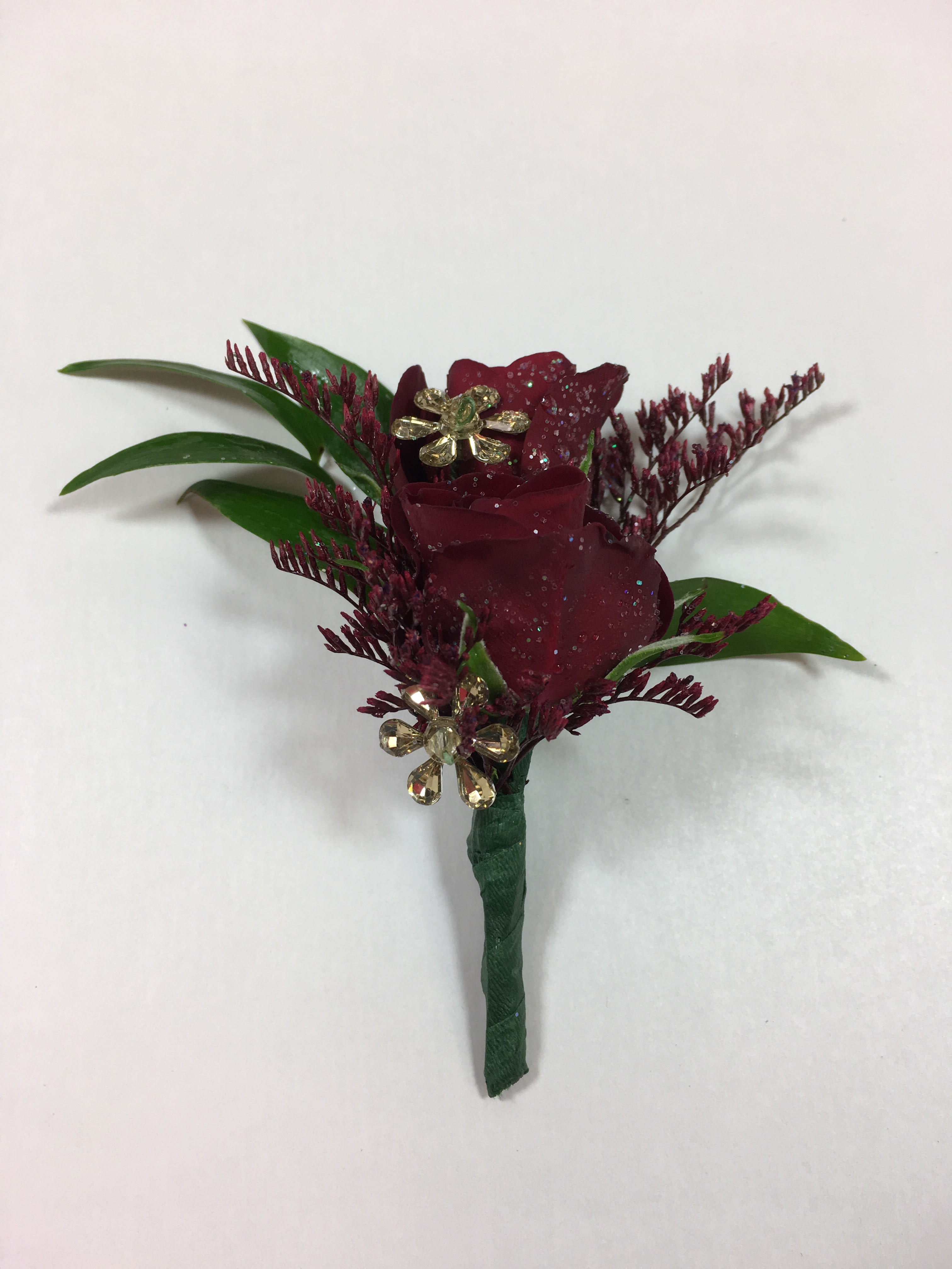 B3 Spray Rose Boutonniere B3 Spray Rose Boutonniere - Burgundy Spray Roses, burgundy sprayed limonium and gold jewels. Each prom order is customized to coordinate with your date's flowers and her beautiful dress.