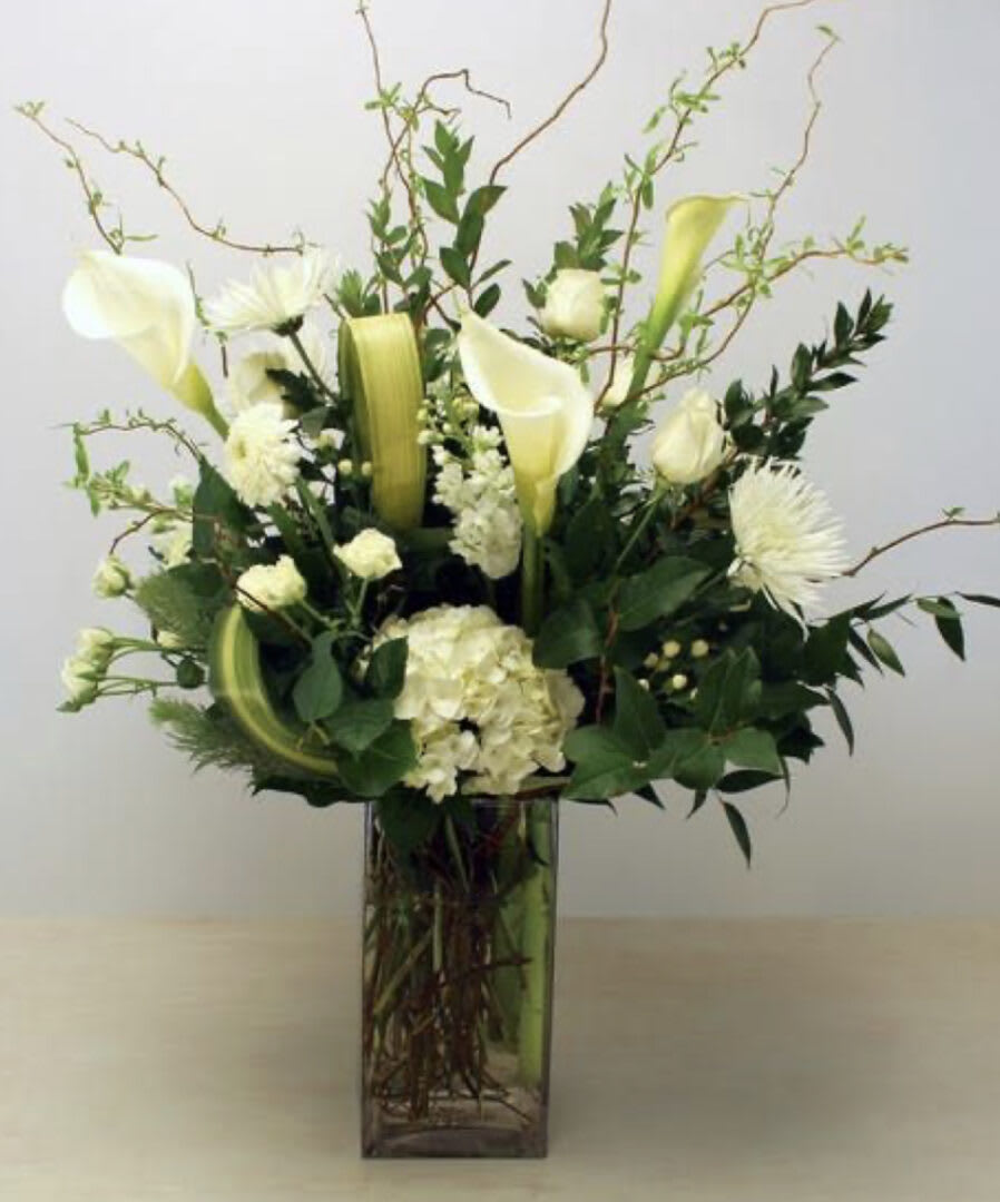 EXPRESIONS - &quot;Three of the most popular and most loved of all plants, beautifully presented in a stylish bamboo or wood rectangle vase is a gift that will bring many days of joy. This mix of Spathiphyllum peace lily, photos, dracaena, and bird of paradise, accented with river rocks, is delivered in a brown bamboo rectangle • SET: All-Around • All prices in USD ($) • Standard&quot;
