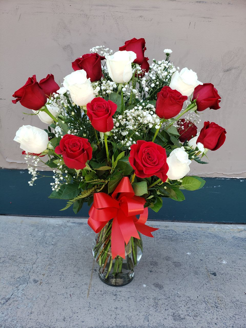 Sending Love And Hugs - 16  red roses with  12 white roses with   greenery  in clear vase.