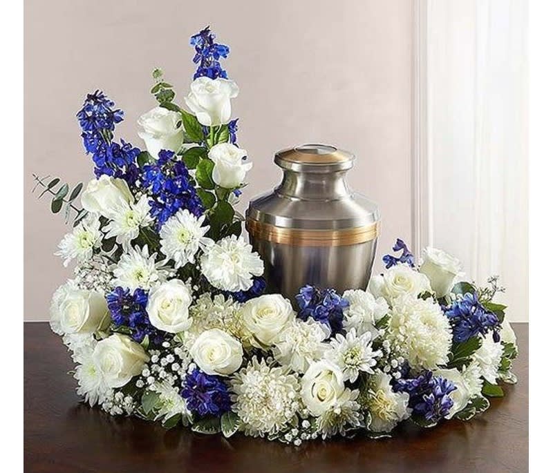 Blue skies urn piece - This Urn piece is a perfect accent to your loved ones memorial. White roses, mums, babies breath and blue delphinium serenely swirl around the uniquely chosen urn. (Colors can be customized upon request)