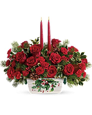 Teleflora's Holly Glow Centerpiece - Bring a warm glow to holiday décor with this radiant centerpiece of festive red roses and taper candles, arranged in a keepsake stoneware serving dish. This festive centerpiece features red roses, red spray roses, red carnations, red miniature carnations, douglas fir, variegated holly, and magnolia leaves. Delivered in Teleflora's Halls Of Holly dish.   Orientation : All-Around  All prices in USD ($)  Standard  T18X105A  Deluxe  T18X105B  Premium  T18X105C