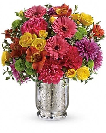 Teleflora's Pleased As Punch Bouquet - Like a glass of party punch, this juicy bouquet of bold pink, yellow and purple flowers will refresh and revitalize your lucky someone. Arranged in a shimmering Mercury Glass hurricane, it's one sweet treat! Yellow roses, pink gerberas, orange alstroemeria, hot pink carnations, green button chrysanthemums and purple cushion spray chrysanthemums are accented with oregonia. Delivered in a Mercury Glass hurricane. 