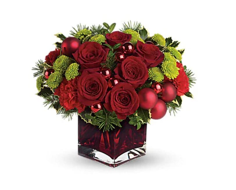 Teleflora's Merry &amp; Bright - You may not be able to guarantee a white Christmas, but with elegant touches like green cymbidium orchids and stunning red roses, you can be assured of sending a merry and bright one! Gorgeous cymbidium orchids, red roses and carnations along with brilliant green button chrysanthemums, shiny red ornament balls and winter greens are perfectly arranged in this very merry Christmas cube.   Orientation : All-Around  All prices in USD ($)  Standard  T125-1A  Deluxe  T125-1B  Premium  T125-1C