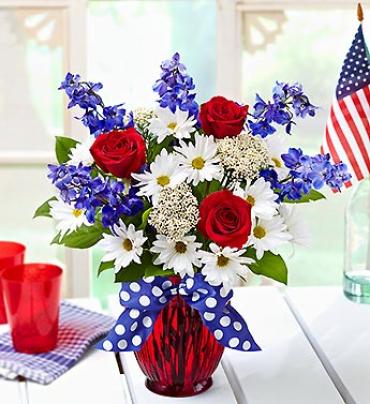 The American Dream Bouquet The American Dream Bouquet - Make their celebration red, white and beautiful with this truly original (and purely patriotic) arrangement. Our florists design fresh red roses, blue delphinium and white daisy poms in a ruby red ribbed glass vase, and finish it off with a royal blue and white polka-dotted ribbon. (Vase/Basket style may vary) Item # 91128