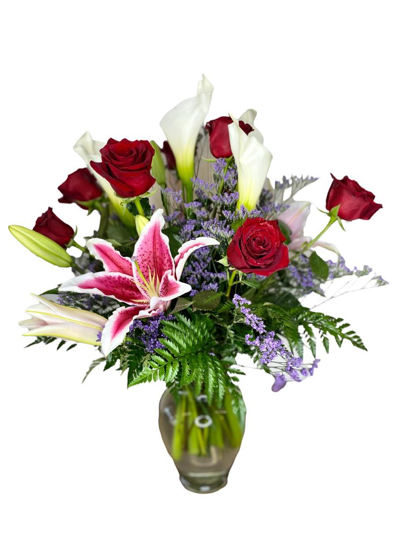 Romance Hugs Romance Hugs - The perfect blend of romance, featuring calla lily, Stargazer Lily, red roses, with some misty blue and leather-leaf fern.