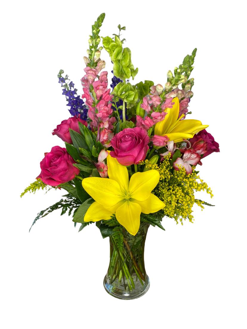 Vibrant Medley Bouquet - This vibrant arrangement features pink roses, yellow lilies, snap dragon flower, bell of the ireland solid aster, larkspurs. Complimented with the following fillers leather-leaf fern and solidaster flowers
