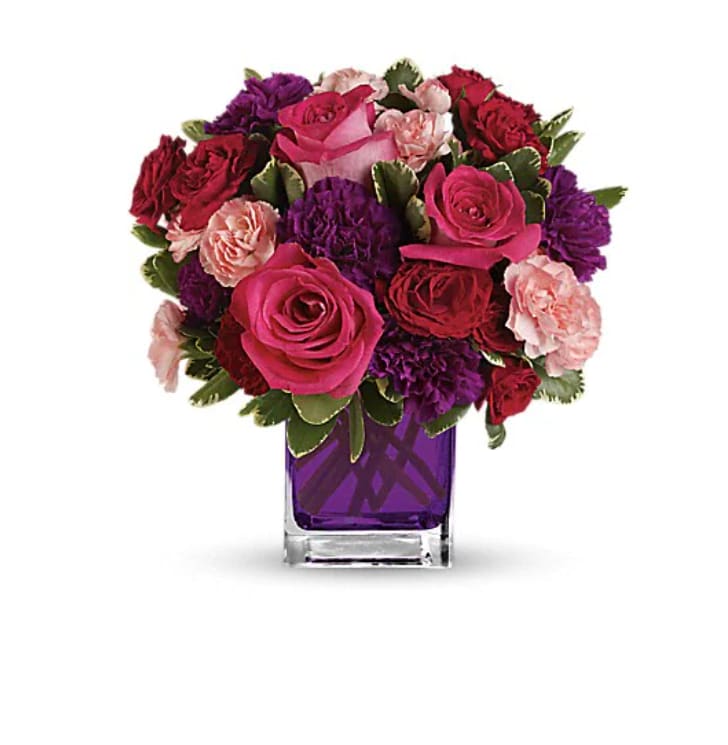 Bejeweled Beauty by Teleflora Bejeweled Beauty by Teleflora - Pure romance. Hot pink roses and dark red spray roses are brightly arranged inside our violet cube. Hot pink roses, dark red spray roses, purple carnations and pink miniature carnations are accented with assorted greens. Delivered in Teleflora's glass violet cube.