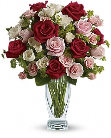 Cupid's Creation with Red Roses by Teleflora - Classic beauty and romance to spare, thanks to the graceful lines of a Couture Vase filled with stunning roses - the iconic flower of love. Like the arrow released from Cupid's bow, this gorgeous bouquet will go straight to your lover's heart. Exquisite red and pink roses, white and light pink spray roses and greens are perfectly arranged in a lovely Couture Vase. This is an inspired way to celebrate your love. 