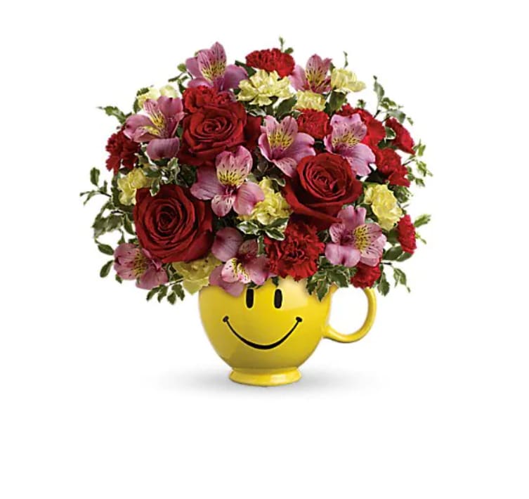 So Happy You're Mine Bouquet by Teleflora - Send smiles across the miles with this magnificent mug of blooms! Sure to become their favorite for morning coffee, this sweet ceramic design brims with lush red roses, pink alstroemeria and miniature red and yellow carnations. It's a great way to send your love! This bouquet features red roses, pink alstroemeria, miniature red carnations, miniature light yellow carnations and pitta negra. Delivered in a Be HappyÂ® Mug. 