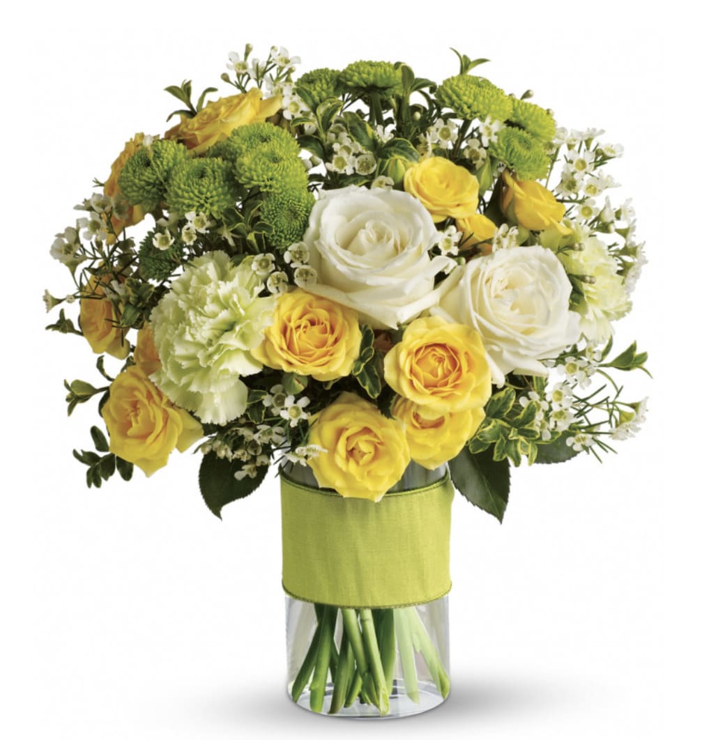 Sweet Smiles Bouquet - Bring a smile to their face with the Sweet Smiles Bouquet! Featuring white roses, yellow spray roses, green carnations, green button spray chrysanthemums and white waxflower accented with assorted greenery and expertly designed in a glass cylinder vase.