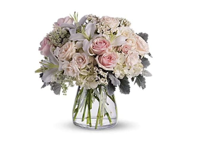 Beautiful Whisper Beautiful Whisper - A whisper-quiet affirmation of love. Subtle shadings of pink and white roses, lilies and delicate Queen Anne's lace in a simple, elegant vase. Gorgeous flowers such as white, crème and light pink roses, white oriental lilies and delicate Queen Anne's lace with a touch of silvery dusty miller, all in a classic hurricane vase. Orientation : All-Around All prices in USD ($) Due to seasonal price increase on flowers, our prices will reflect an increase for this holiday on certain delivery dates. Standard T237-1A