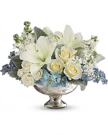 Telflora's Elegant Affair Centerpiece - As magical and unforgettable as an elegant affair! Creamy roses and snow white lilies are accented with whisper blue blooms in this regal arrangement, hand-delivered in a classic silver mercury glass bowl. An impressive, elegant choice no matter the occasion. This elegant mix includes light blue hydrangea, white roses, white spray roses, white asiatic lilies, white carnations, light blue delphinium, white stock and dusty miller. Delivered in a silver mercury glass bowl. 
