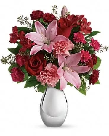 Teleflora's Moonlight Kiss Bouquet - She'll feel the love when she receives this gorgeous array of roses, lilies and more artistically arranged in a dazzling silver reflections vase. You'll also feel the love when she finishes oohing and aahing and turns to thank you. This romantic bouquet includes red roses, red spray roses, pink asiatic lilies, red alstroemeria, pink carnations and pink miniature carnations accented with assorted greenery. Delivered in a silver reflections vase. 
