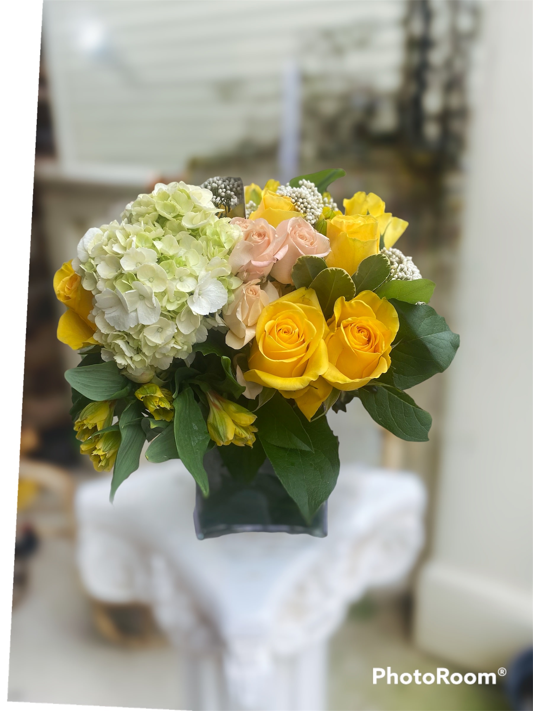 Lady Waleska Lady Waleska - Yellow roses and hydrangeas are paired with peach flowering carnations and seasonal greenery.