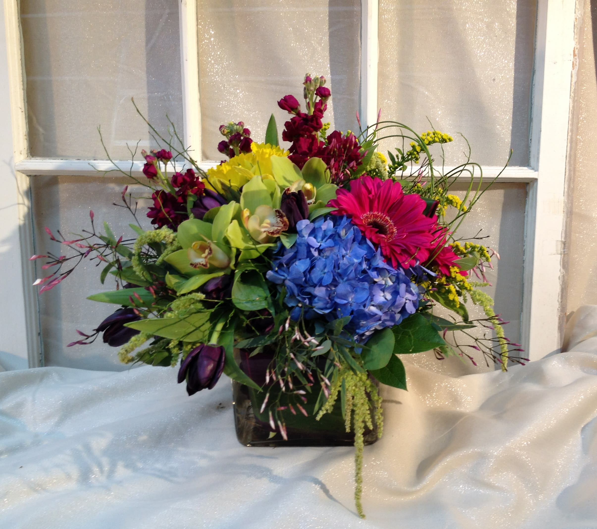 Broadway Broadway - Classic custom bouquet of seasonal flowers with hydrangea, cymbidium orchids, tulips, stock and gerbera daisies designed in a square vase.