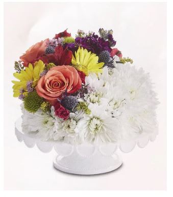 Brightest Day Flower Birthday Cake - Make their birthday the brightest day of the year! Our unique flower cake is gathered with a bed of bright white poms and a crescent-shaped spray of colorful blooms on one side. This confection-inspired creation is the perfect centerpiece for celebrating someone special. Add to the fun with a festive balloon.  ****** VASE PLATE WILL VARY *******