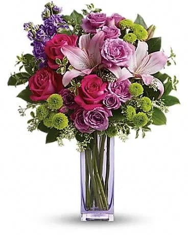 Teleflora's Fresh Flourish Bouquet - Color them happy with this bold, beautiful mix of hot pinks, flirty lavenders, and lime greens! Hand-delivered in a lavender glass vase, this posh present pampers your loved one on a special day - or any day at all! This luxe bouquet includes hot pink roses, lavender spray roses, pink asiatic lilies, lavender stock, green button spray chrysanthemums, pitta negra, seeded eucalyptus and lemon leaf. Delivered in a lavender vase. 