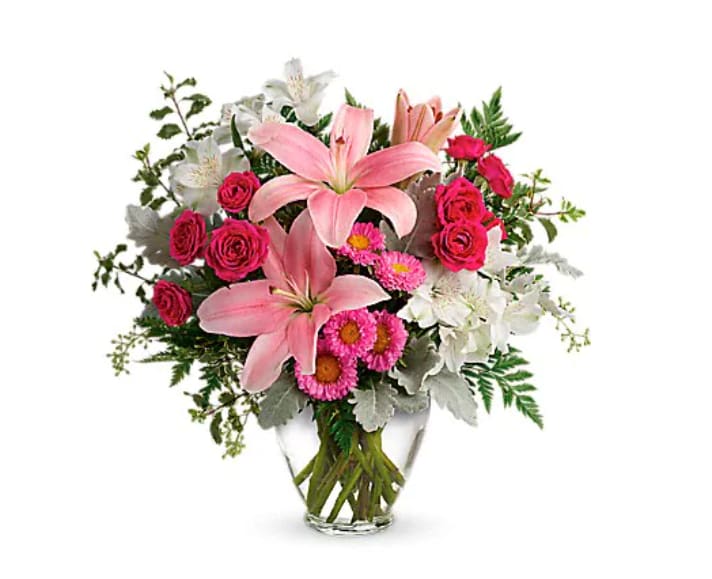 Blush Rush Bouquet - Luxe lilies in a beautifully blushing shade of pink are sure to make them smile, no matter the occasion! This pretty bouquet features hot pink spray roses, pink asiatic lilies, white alstroemeria, pink matsumoto asters, seeded eucalyptus, leatherleaf fern, dusty miller, and pitta negra. Delivered in a Serenity Vase.   Orientation : One-Sided  All prices in USD ($)  Due to seasonal price increase on flowers, our prices will reflect an increase for this holiday on certain delivery dates.  Standard  TEV55-5A  Deluxe  TEV55-5B  Premium  TEV55-5C