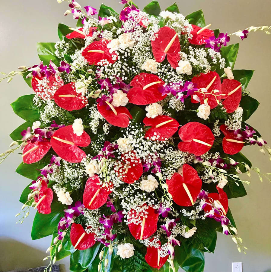 Red heart shaped wreath surrounded by Anthuriums and Orchids