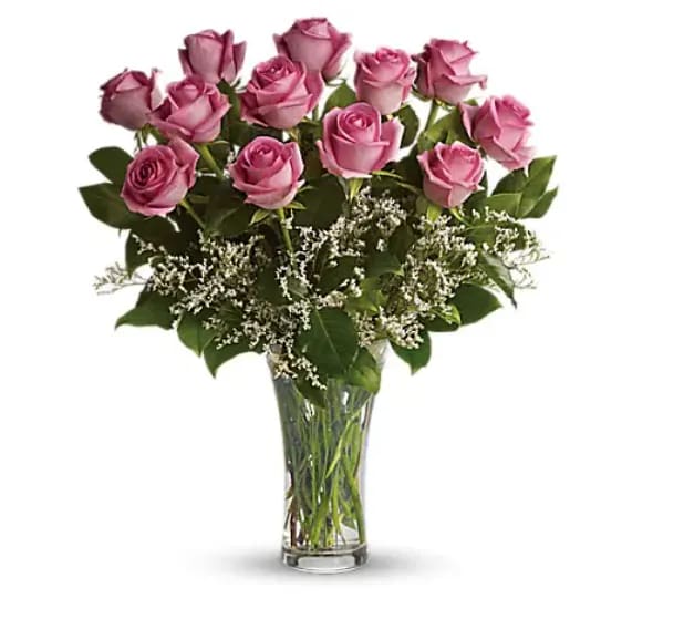 Make Me Blush - Dozen Long Stemmed Pink Roses - It's fun to be flirty! Send a dozen roses to the one you love and she just might make you blush. Especially if the dozen roses in question are this gorgeous! This arrangement is sweet and innocent as can be. Of course, it's a bit sassy and a whole lot sexy, as well. Sending a dozen perfectly pink roses and white limonium arranged in a glass vase to the woman you love shows that you know how much fun love is! And every woman appreciates that! 