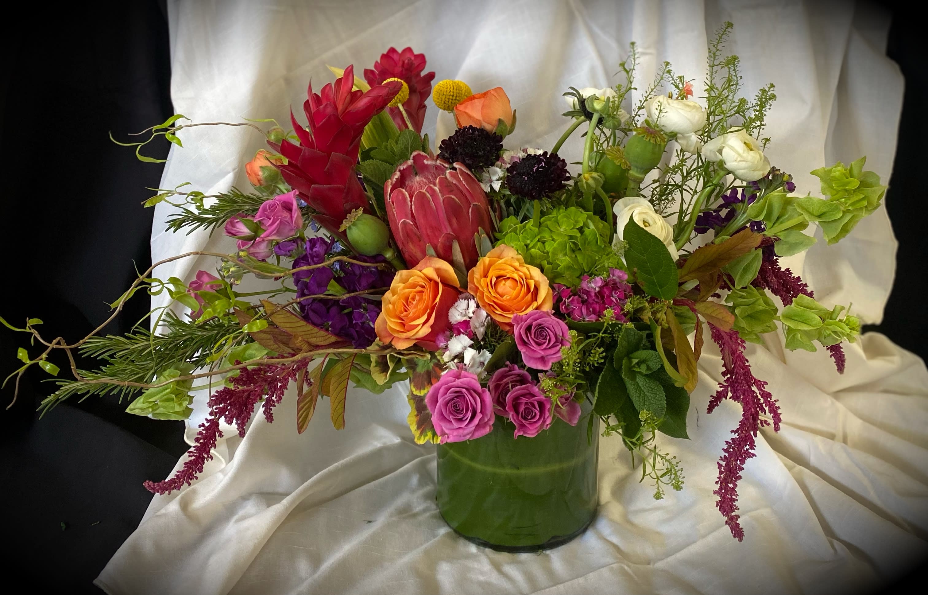 Farmhouse Fleur - A gathering of the season's freshest blooms. Vibrant tone with just the right mix of textural foliage. This Bouquet comes arranged in a 6x6 Cylinder. Overall Finished at an impressive 14x22.