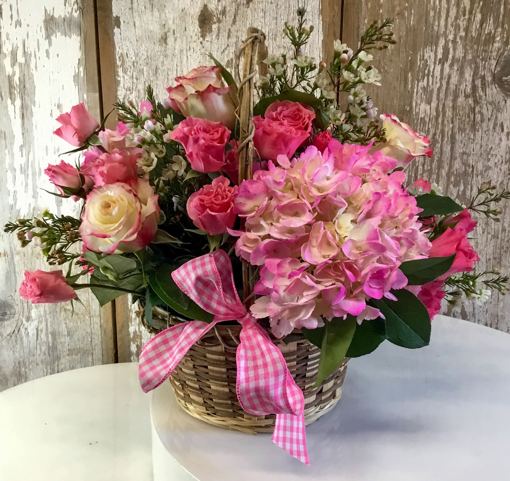 Pretty in Pink - White Daisies or Mums, Hot Pink and Light Pink and White Roses and Dusty Miller with Greens and Wax Flower in a Basket with Ribbon.