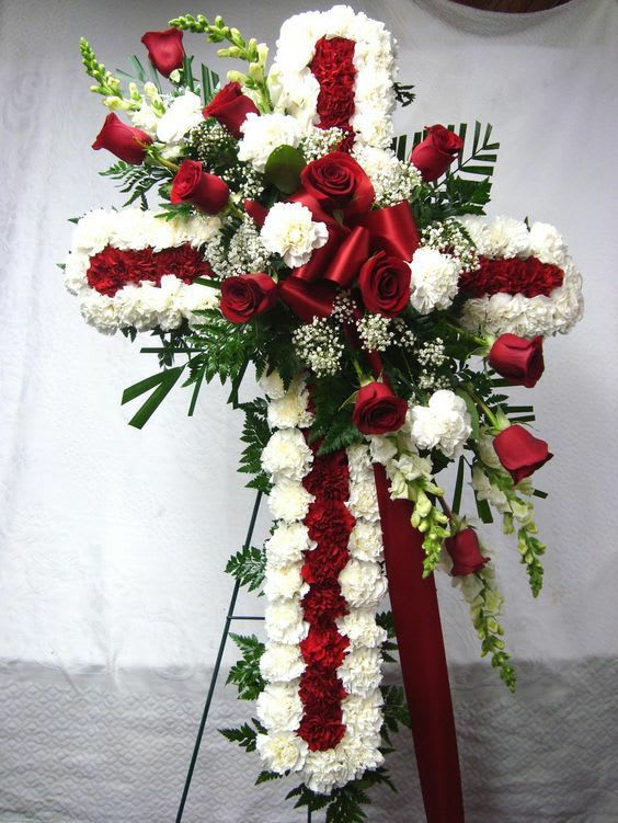 The Cross The Cross - 25 white carnation,20 red carnation,5 white snapdragon,12 red roses ,white baby breath and a red bow, 18 inch approx. with a easel.