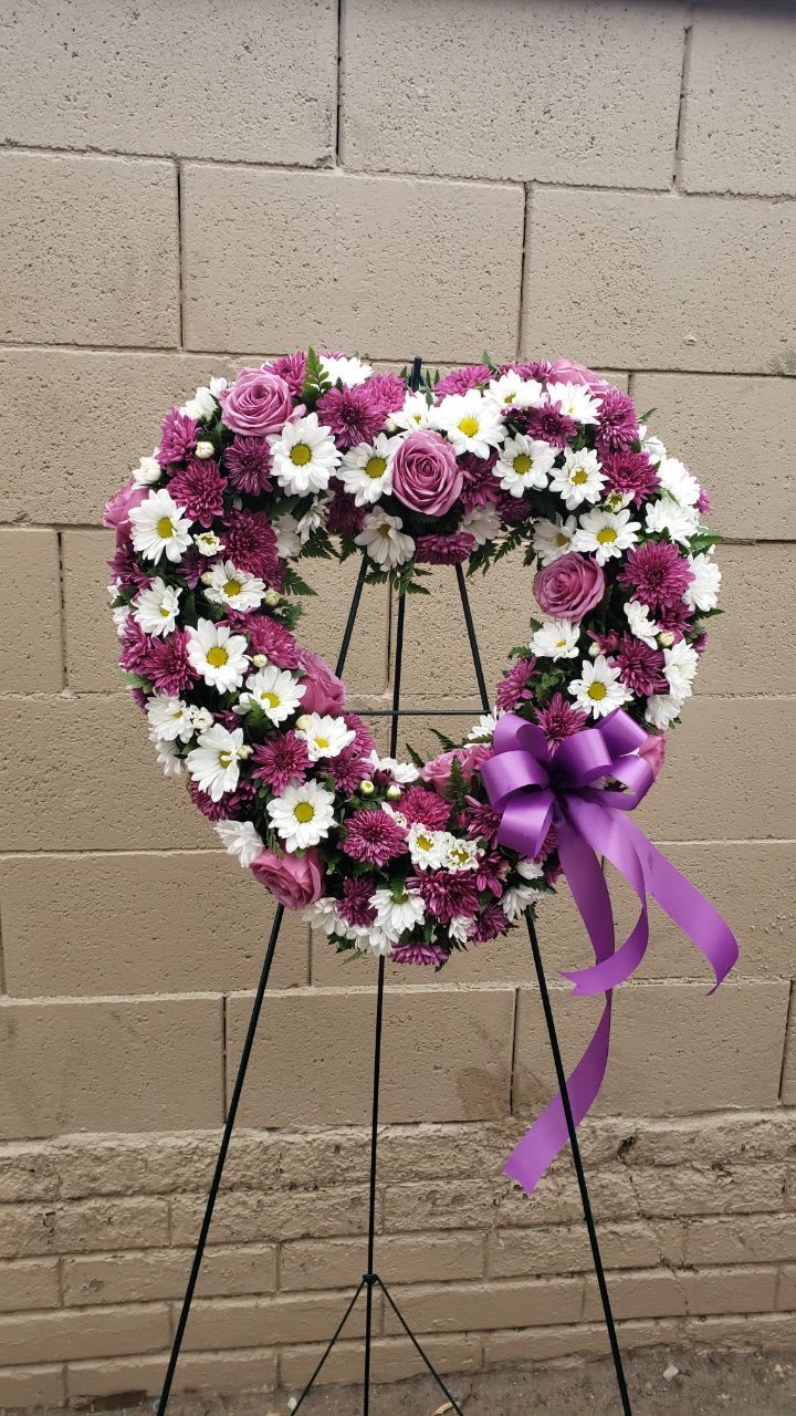 the purple heart the purple heart - 15 purple roses,5 stems of purple cushion, 5 stems of white daisies, purple bow the heart is 18 inch approx. comes with a easel