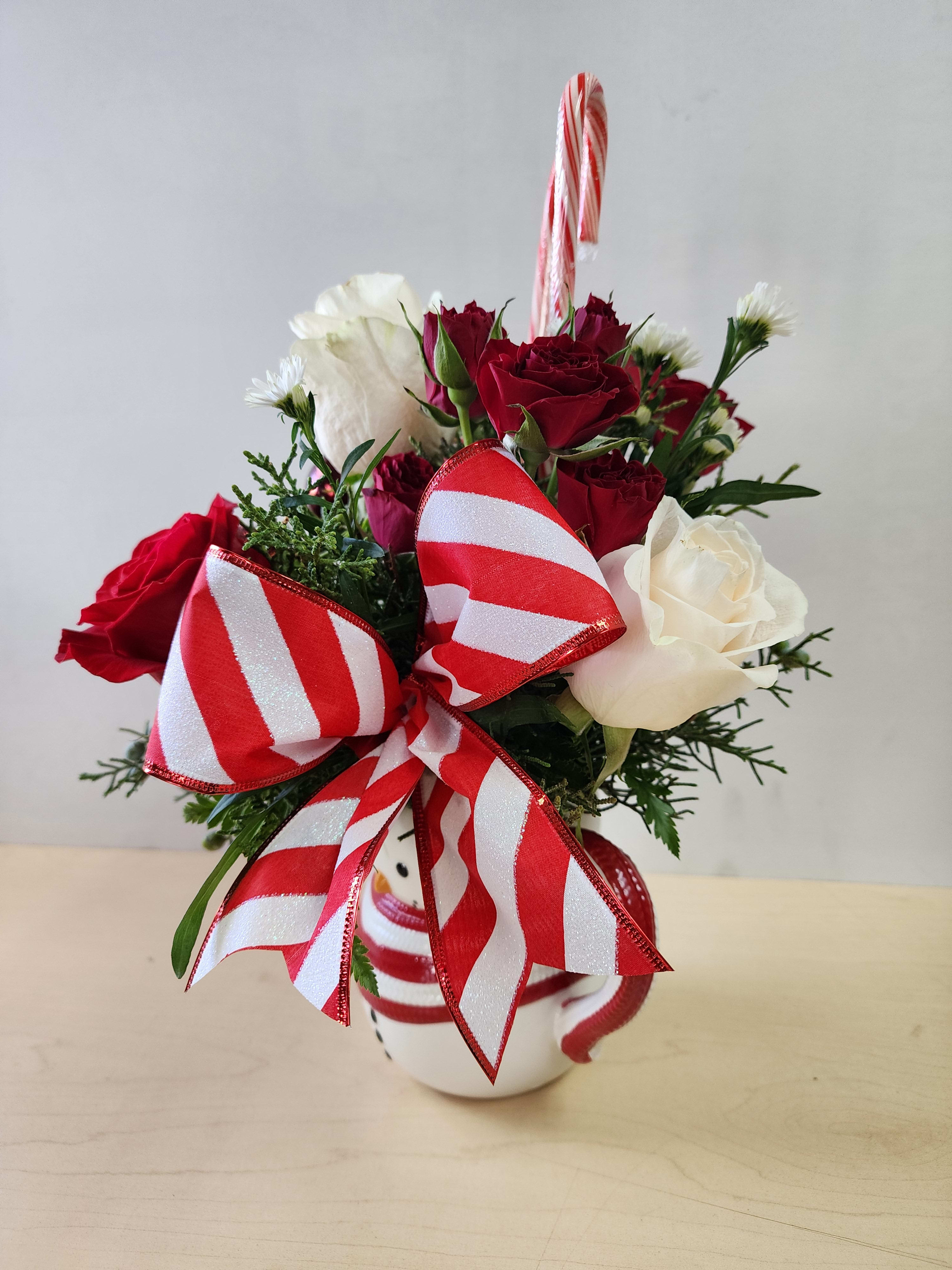 The Frosty Heart - 2- Red Roses 2-Pc white Roses 2 stem of red s Pray Roses 1 stem of white monte Casino 3 ornaments. 2 Candy Canes, Seasonal bow in a sweet Frosty Mug