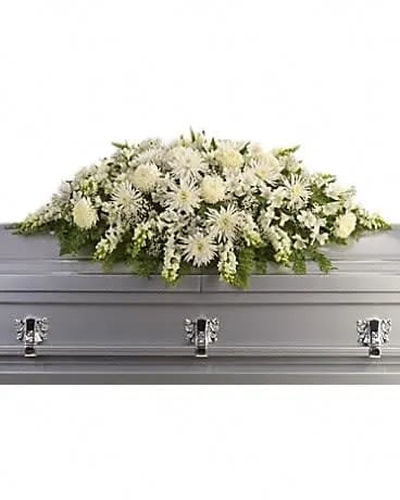 Enduring Light Casket Spray - The purity of this all-white casket spray creates an aura of serenity and peace - a beautifully memorable final farewell to a lost loved one. The elegant arrangement includes white alstroemeria, white snapdragons, white chrysanthemums, white spider chrysanthemums and million star gypsophila, accented with assorted greenery. . 