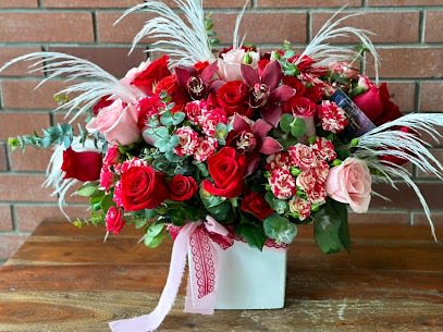 Bohemian Romance Bouquet  - hand-crafted in a decorative white ceramic vase filled with lovely red roses and spray roses, pink roses and spray roses, lovely orchids, eucalyptus and preserved pampas grass with greenery and filler flowers, 