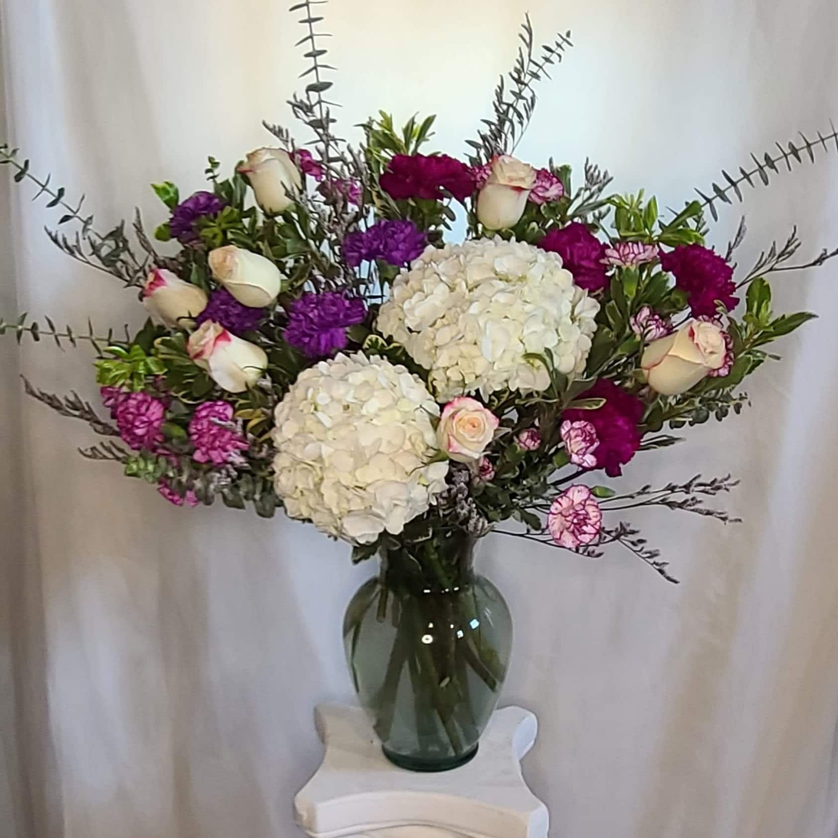 Here's to 10 - Passion created in a vase. Roses, lilies, hydrangea, carnations, with even more accents of colorand lush greens